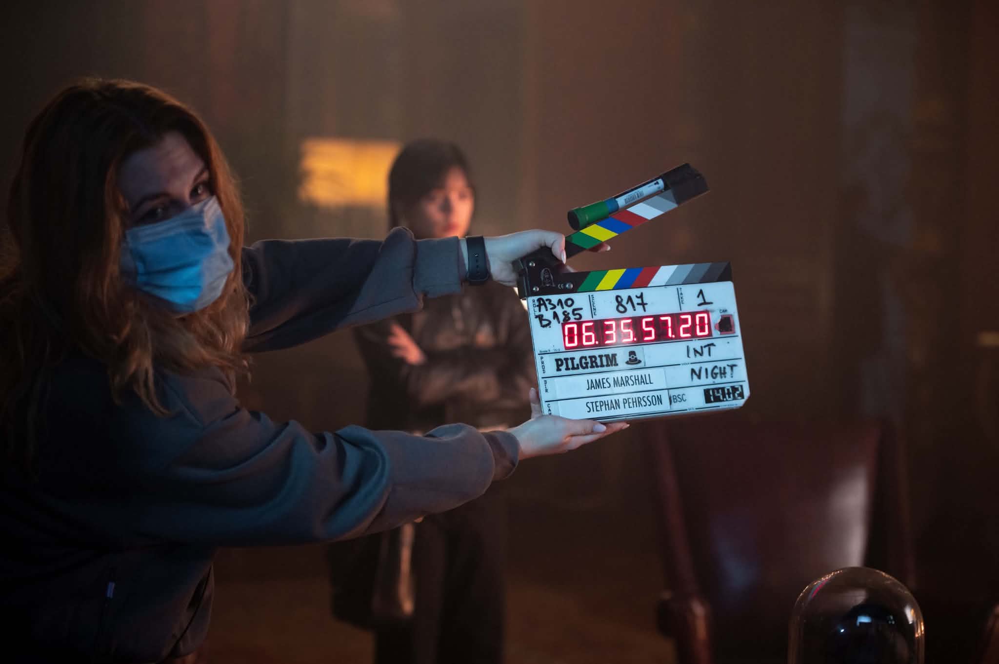 Adelina on set, clapperboard in hand